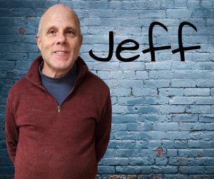 Finger Lakes Independence Center Advocacy Specialist Jeff Boles in front of a grey brick wall with first name in black letters
