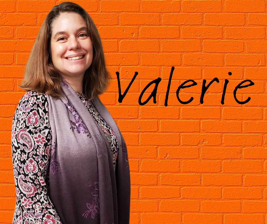 FLIC Advocacy & Support Specialist Valerie Foster Githinji Finger Lakes Independence Center Advocacy & Support Specialist Valerie Foster Githinji in front of a orange brick wall with first name in black letters