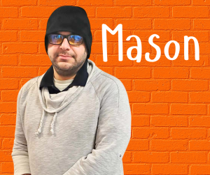 Finger Lakes Independence Center Mason Douglas in front of a orange brick wall with first name in white letters